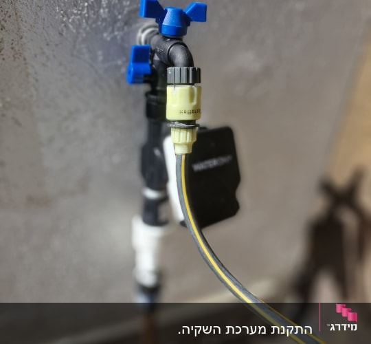 ברז השקיה עם צינור מחובר לקיר